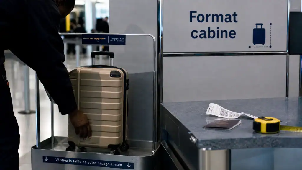 Valise cabine format, agent mesure le gabarit en aéroport